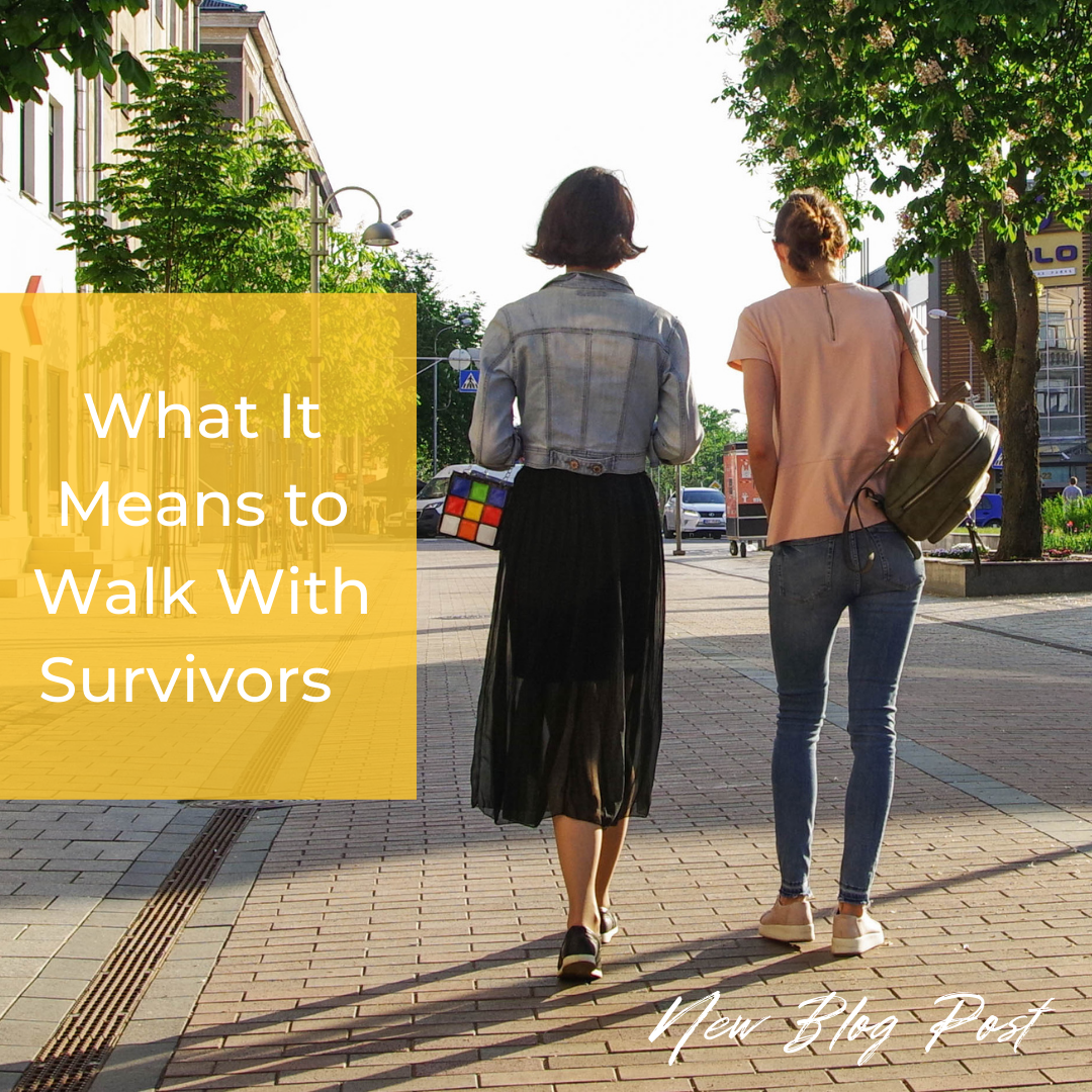 Two women walk away down the street during sunset