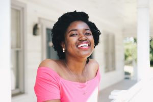 Woman laughs while leaning over the edge of a porch